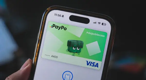Jak dodać kartę do telefonu? Na ekranie smartfona widać aplikację PayPo z wirtualną kartą Visa i instrukcją zbliżenia do czytnika.