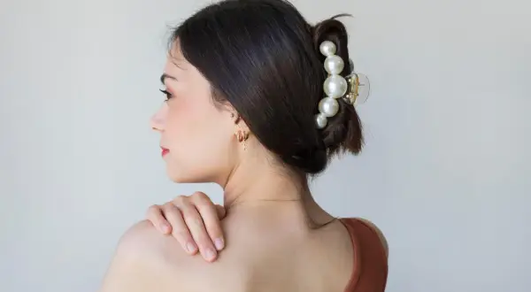 Elegante claw clip frisuren mit Perlen verzieren den Dutt einer Frau.