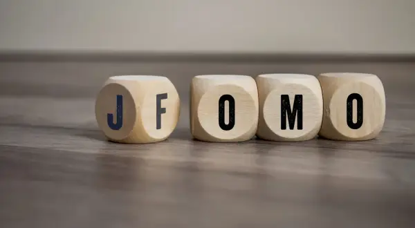 Drewniane kostki z literami J, F, O, M, O. Czy to FOMO? Strach przed tym, że coś nas omija.