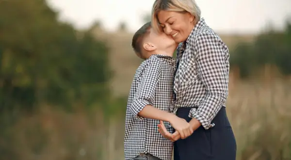 Un bambino bacia la guancia della madre, un gesto d'amore che dimostra che chi ha la mamma è ricc e nun o sap, una vera poesia.