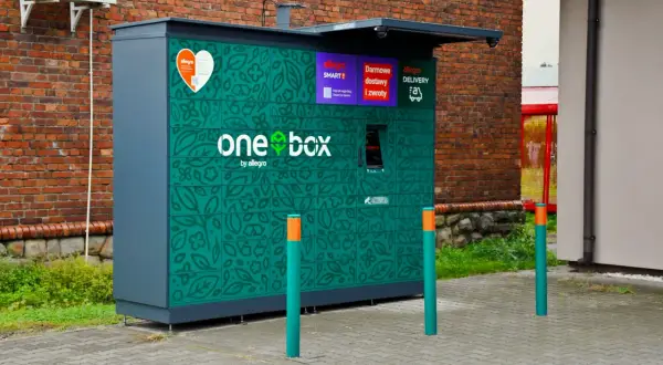 Zielony automat paczkowy Allegro One Box z motywem liści. Wymiary paczkomatu pozwalają na wygodne odbieranie i nadawanie przesyłek.