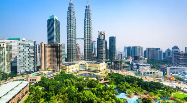 Piękna pogoda w Malezji! Wieżowce Petronas i zieleń parku miejskiego w Kuala Lumpur.