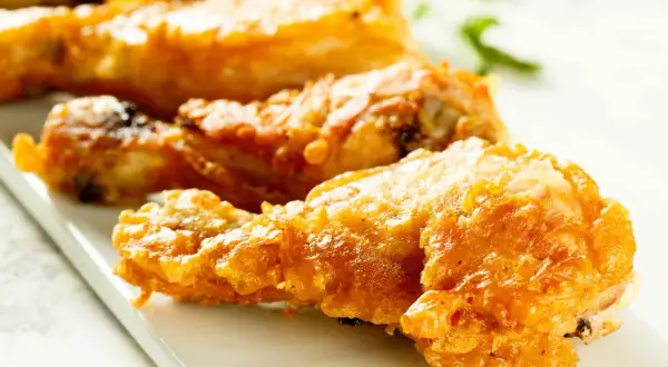 Muslos de pollo crujientes y dorados, recién salidos de la freidora de aire. Perfectos para una comida rápida y deliciosa.