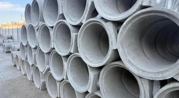 Stos betonowych rur kanalizacyjnych. Każda rura ma pojemność kręgu betonowego 100, gotowa do budowy infrastruktury.