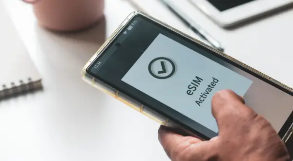 Smartfon z komunikatem "eSIM Activated" na ekranie. Dowiedz się, jak przenieść esim na inny telefon.
