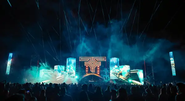 Nocny festiwal muzyczny z laserami i ekranami LED. Tłum ludzi bawi się przy muzyce na żywo.