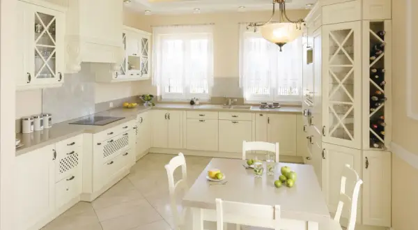 Jasna kuchnia z kredensem, inspiracje dla eleganckiego wnętrza. Jasne meble, duży kredens z miejscem na wino i szkło.