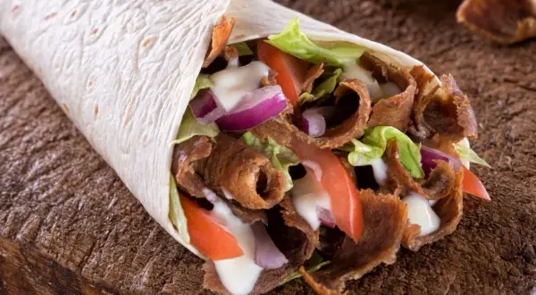 Domowy kebab w tortilli z mięsem, warzywami i sosem. Prosty przepis na to, jak zrobić kebab w domu.