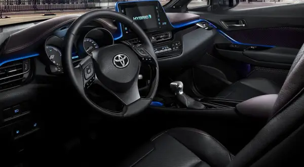 Interiör i en Toyota C-HR Hybrid. En del tycker att den blå accentbelysningen är en charmig detalj, andra ser det som ett potentiellt toyota chr problem.