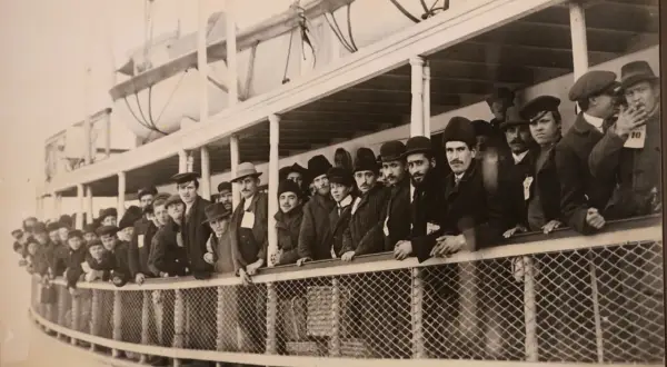Une foule d'immigrants, hommes et garçons, sur le pont d'un navire, attendant d'arriver à Ellis Island.
