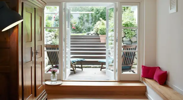 Ein heller Raum mit Holzboden und einer Tür zum Garten. Perfekt, um den **Keller auszubauen** und diesen Ausblick zu genießen.