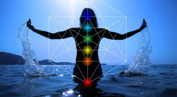 Silueta de persona en el agua con brazos extendidos, salpicando agua. Geometría sagrada y chakras visibles, indicando un posible segundo chakra bloqueado.