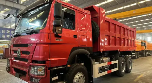 Camion benne rouge brillant, prêt pour le travail. Sa robustesse suggère une faible consommation pour sa catégorie.