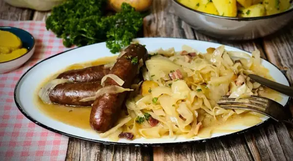 Herzhaftes bayrisch Kraut mit drei Würsten, Zwiebeln und Speck. Dazu Salzkartoffeln und Petersilie.