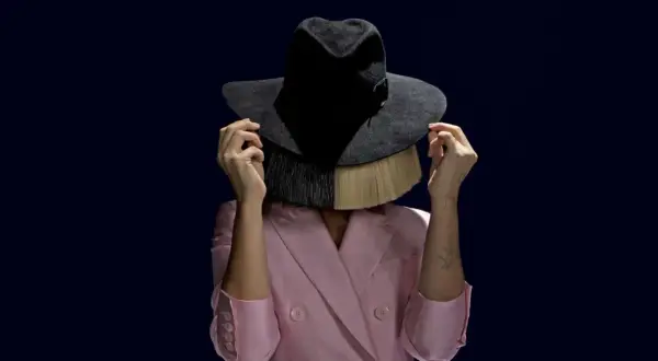 Sia w różowym żakiecie i kapeluszu zasłaniającym twarz, z blond włosami i frędzlami. Tekst "cheap thrills" idealnie pasuje do tej stylizacji.