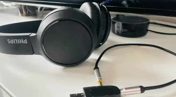 Czarne słuchawki Philips z adapterem audio TX/RX i Amazon Echo Dot.