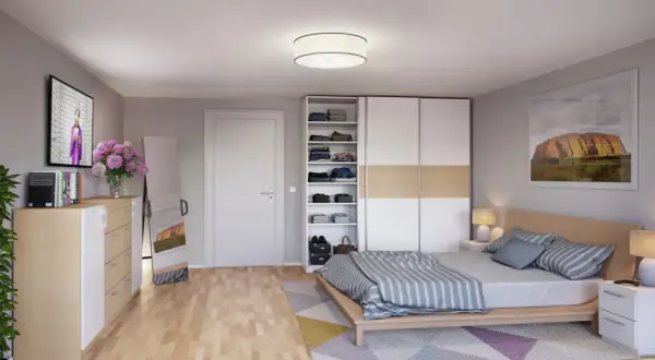 Ein gemütliches wohn- und schlafzimmer in einem kleinen raum mit Bett, Kleiderschrank, Kommode, Spiegel und TV.