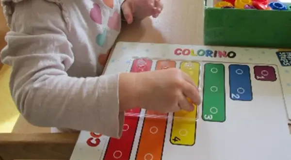 Ein Kind lernt im Kindergarten spielerisch Formen und Farben mit dem Spiel "Colorino".