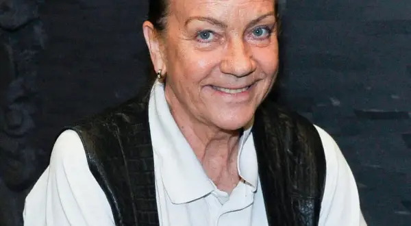 Barbara Burska uśmiecha się, nosząc czarną kamizelkę na białej koszuli.