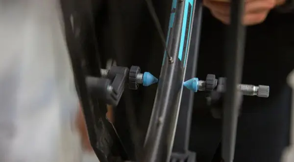 Fietsband met een slag uit wiel halen. Een blauwe dop op het ventiel, klaar voor reparatie.