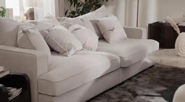 En ljus, fluffig soffa med många kuddar. Perfekt för att mysa i efter att du valt att impregnera soffan för extra skydd.