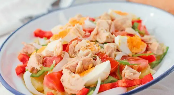 Ensalada campera con atún desmigado, huevo duro, tomate, pimiento y cebolla. Un plato fresco y completo.