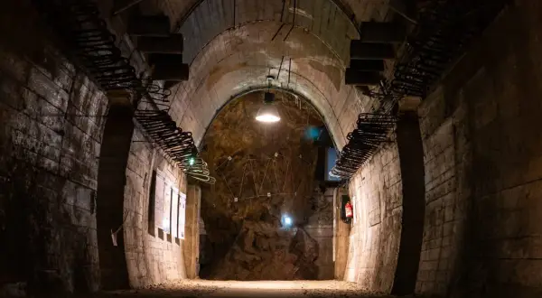 Mroczny tunel w górach sowich, z odsłoniętymi elementami konstrukcyjnymi i oświetleniem.