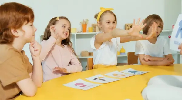 Dzieci uczą się liter na kartach. Czy żłobek podlega pod kuratorium? To pytanie nurtuje wielu rodziców, ale tu maluchy skupione są na nauce.
