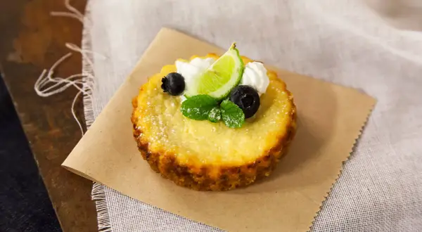 Deliciosa torta de ricota, decorada con arándanos, menta, crema y una rodaja de lima.