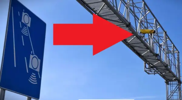 Niebieski znak informuje o odcinkowym pomiarze prędkości S7. Czerwona strzałka wskazuje na żółtą kamerę zamontowaną na konstrukcji nad drogą.