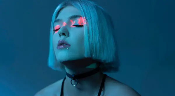 Daria Zawiałow w neonowym świetle, jej oczy ozdobione czerwonymi wzorami. Nowe płyty już wkrótce!