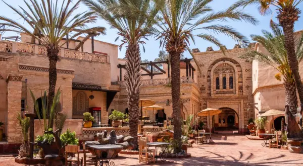 Agadir co zobaczyc: urokliwy dziedziniec z palmami, tradycyjną architekturą i miejscami do siedzenia. Idealne miejsce na relaks.
