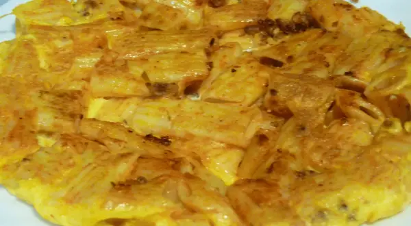 Tortilla de macarrones dorada y apetitosa, con trozos de pasta integrados en el huevo. ¡Un plato casero perfecto!