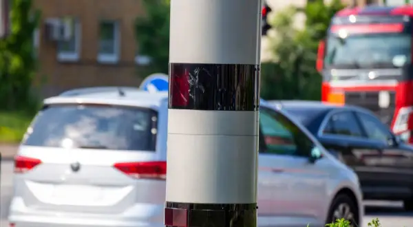 Ein Blitzer ohne Blitz: Dieses Gerät überwacht den Verkehr. Autos fahren vorbei, ein roter LKW ist im Hintergrund zu sehen.