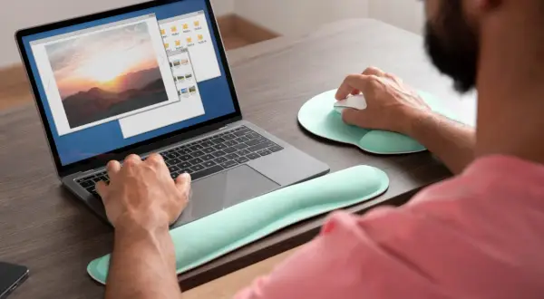 Mężczyzna pracuje na laptopie, przeglądając zdjęcia. Może szukać sposobu, jak wyostrzyć zdjęcie, aby poprawić jego jakość.
