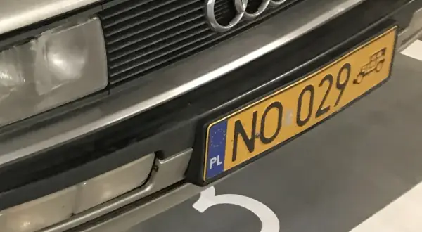Przód Audi z charakterystycznym grillem i czterema pierścieniami. Widoczne żółte tablice rejestracyjne z numerem NO 029.