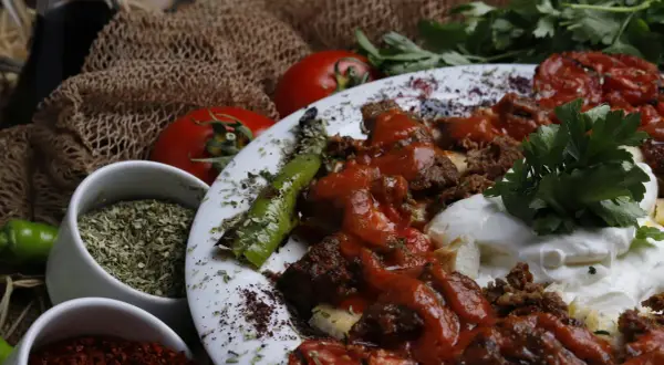Würziges Gericht mit Hackfleisch, Tomaten und Paprika. Sumach-Verwendung zeigt sich in der rubinroten Gewürzmischung, die für Farbe und Aroma sorgt.
