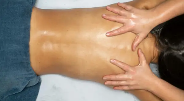 Mains expertes prodiguant un massage dorsal relaxant, soulageant les tensions et apportant une profonde détente.