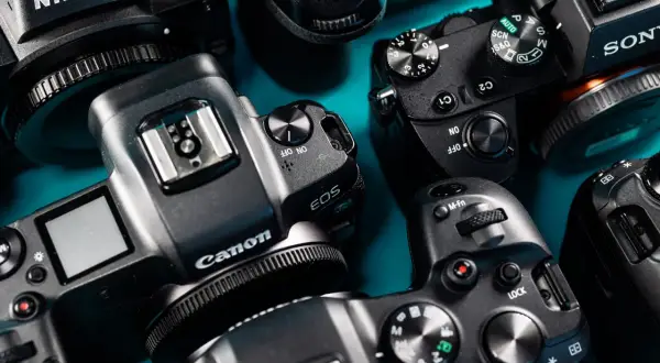 Zbliżenie na kilka aparatów fotograficznych marek Nikon, Canon i Sony. To jest aparat, który pozwala uchwycić wspomnienia.