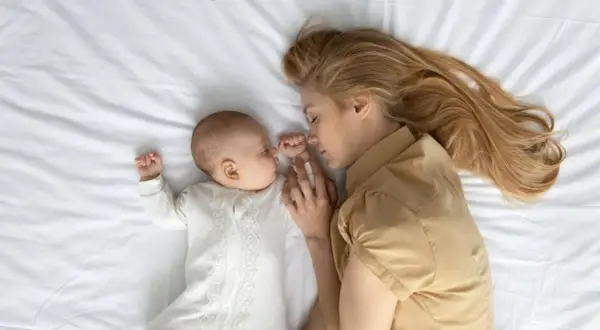 Madre e hijo duermen abrazados. Un momento de paz y conexión, esencial en el tratamiento post parto.