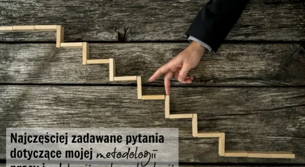 Palce wskazujące mężczyzny w garniturze schodzą po drewnianych schodkach, symbolizując podróż wgłąb siebie i analizę metod pracy.