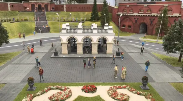 Miniaturowy park w Warszawie z ludzikami spacerującymi po placu przed bramą fortu.