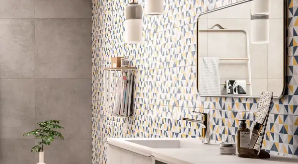 Bagno moderno con parete a triangoli colorati, ideale per chi cerca idee su come rinnovare pavimento in ceramica con stile.