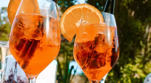 Dwa orzeźwiające drinki z pomarańczą i lodem, idealne na włoski aperitif.