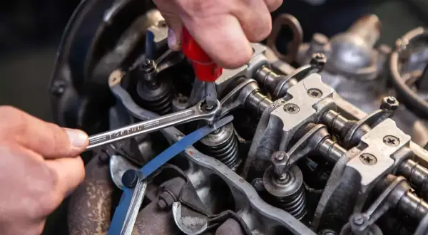 Mechanik reguluje zawory silnika, używając klucza i szczelinomierza. Precyzyjna regulacja zapewnia optymalne działanie, zgodnie z tabelą luzów zaworowych.