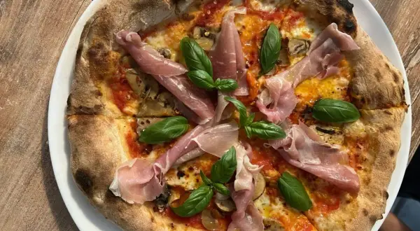 Pyszna pizza z szynką parmeńską i bazylią. Warto sprawdzić ceny w Chorwacji, bo takie smakołyki są warte swojej ceny!