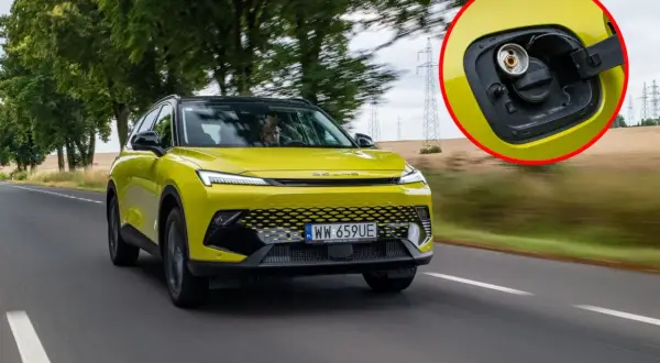 Żółty SUV z fabrycznym LPG na drodze. W powiększeniu widać korek wlewu gazu.