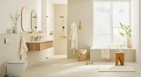 Modernes Badezimmer in hellen Beige- und Cremetönen, ein Trend bei Badezimmer Farben. Goldene Armaturen und Duschkopf setzen Akzente.