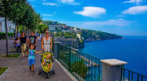 Rodzina spaceruje promenadą, podziwiając piękne widoki na morze i miasto. To idealne miejsce na odkrywanie atrakcji Sorrento.