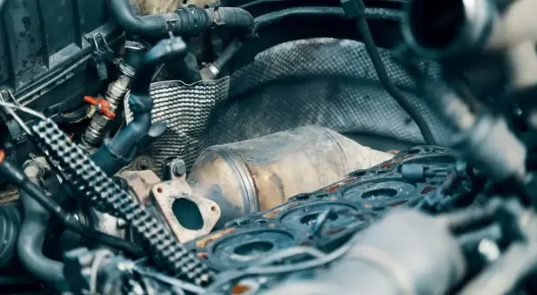 Silnik samochodowy z widocznym elementem układu wydechowego, przypominającym katalizator lub dpf. Co to jest dpf?